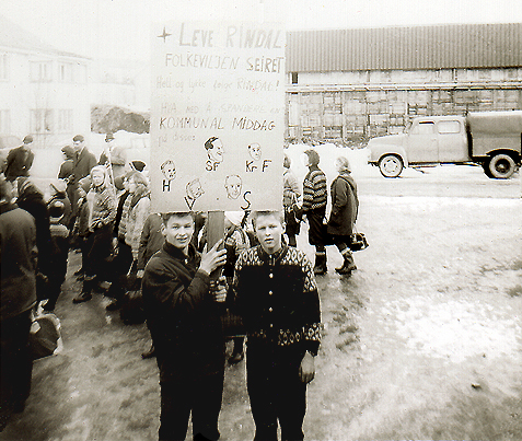 Odd Jostein Sæter og Magne Olav Romundstad med plakaten som lød: «Leve Rindal – Folkeviljen seiret – Hell og lykke følge Rindal! Hva med å spandere en kommunal middag på disse:». Rindal, 1965.